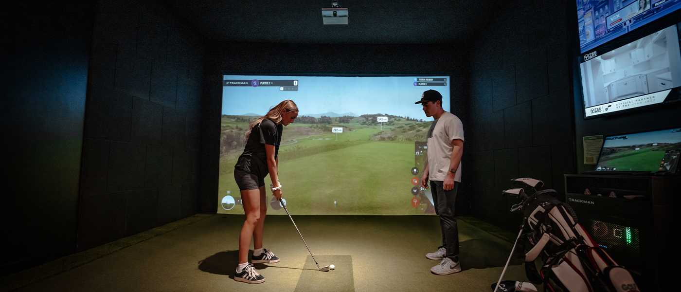 A Tee Box employee working on customizing a golf club for a member, contact us today for golf club fitting.