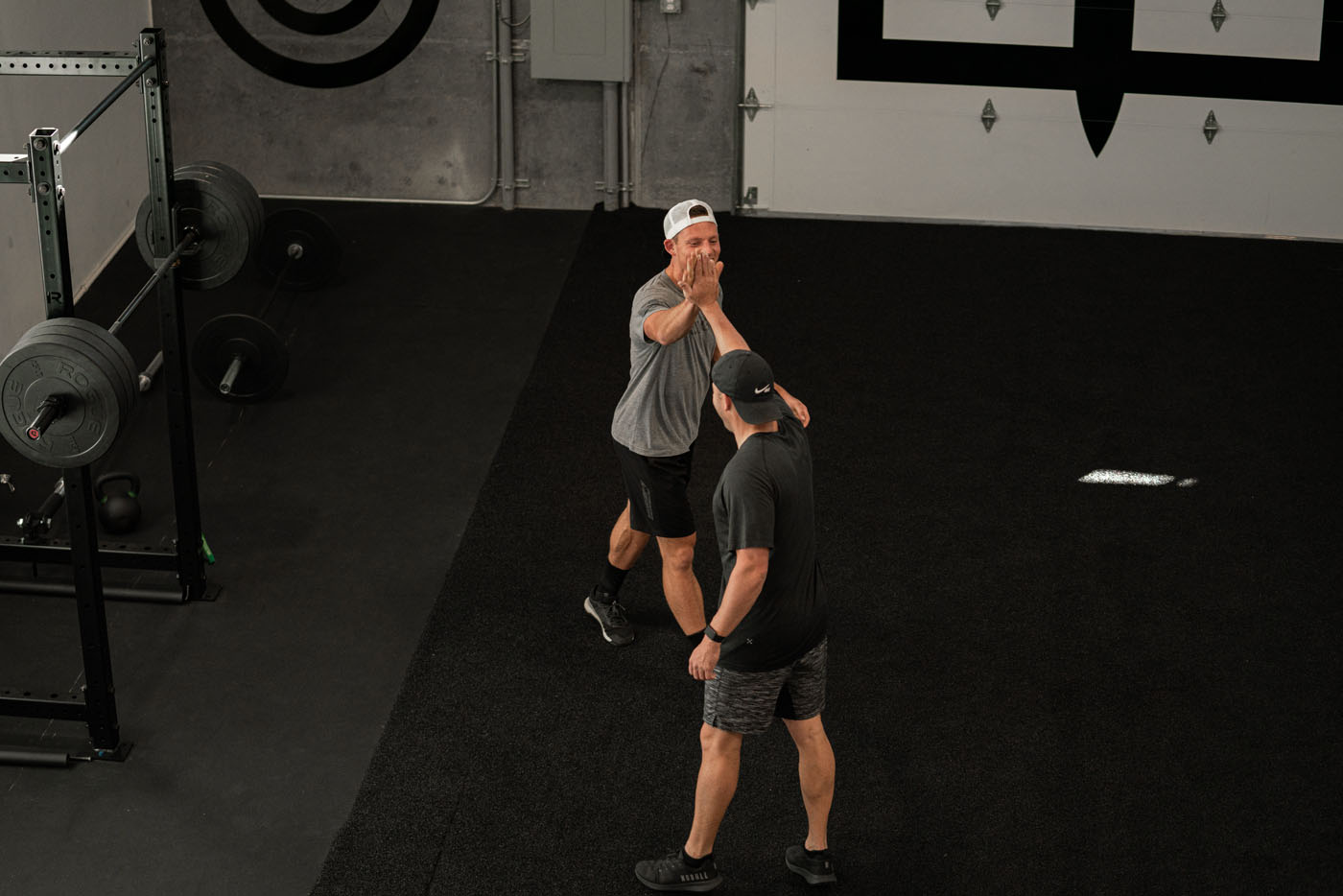Two Tee Box members high fiving in our gym facility.